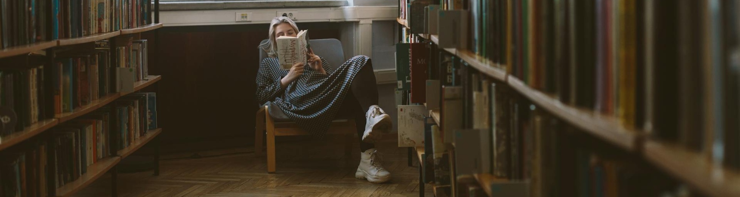 a woman sitting in a chair and reading a book