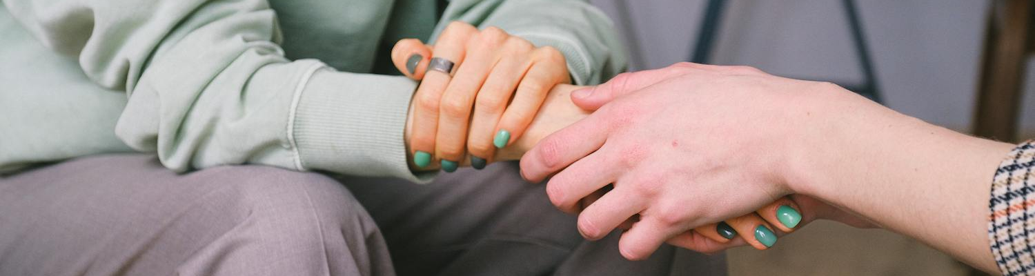 Two people holding hands for support in inpatient drug rehabs. 