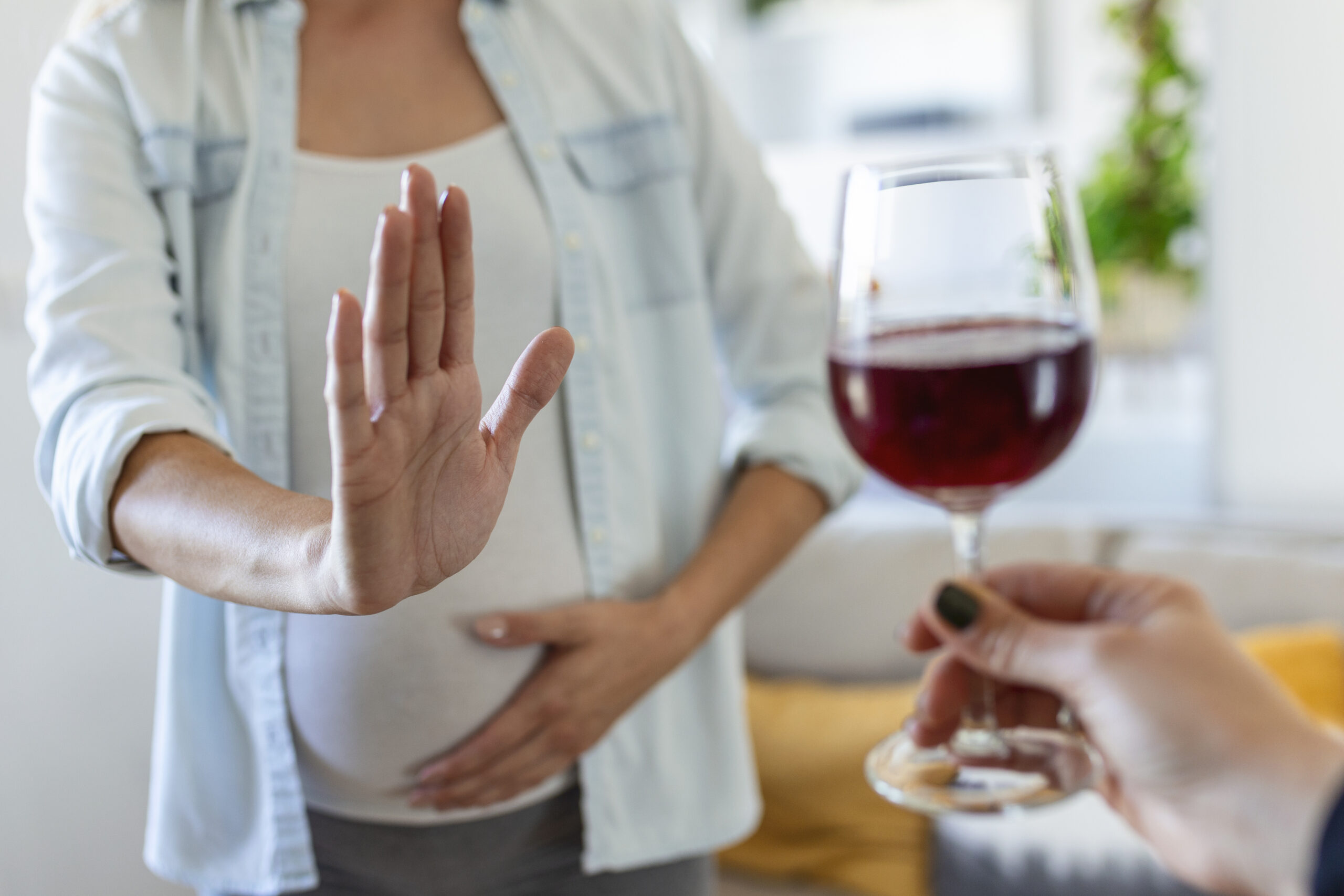 This image shows a pregnant woman refusing an alcohol for the safety of her baby.